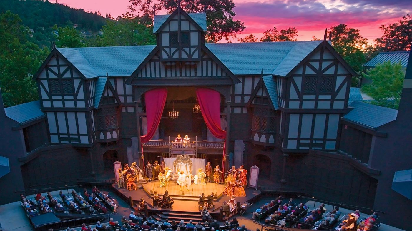 An aerial view of a theater with a sunset in the background.