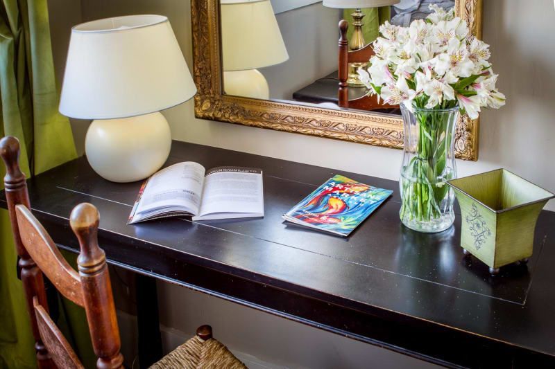 A desk with a vase of flowers and a book on it