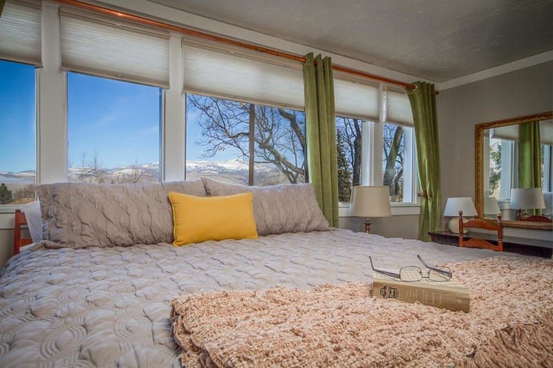 A bedroom with a large bed and a large window.