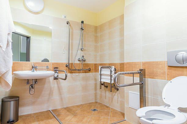 A handicapped bathroom with a toilet, sink, and shower.