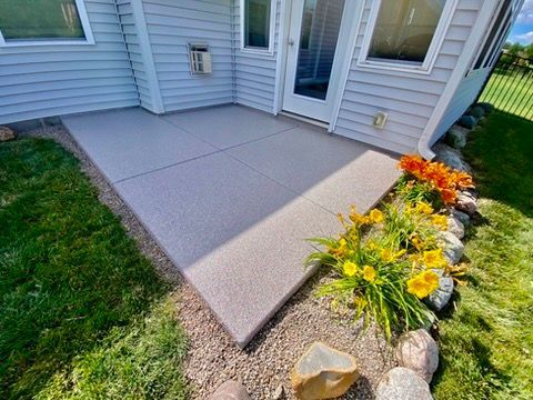 Woman in straw hat smiles, holding wine glass near a lake.