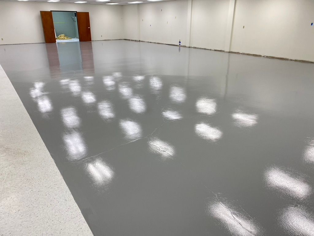 Woman in straw hat smiles, holding wine glass near a lake.