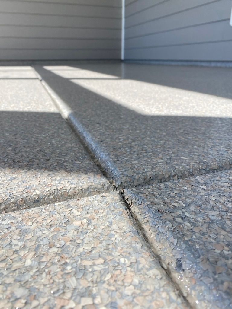 Woman in straw hat smiles, holding wine glass near a lake.