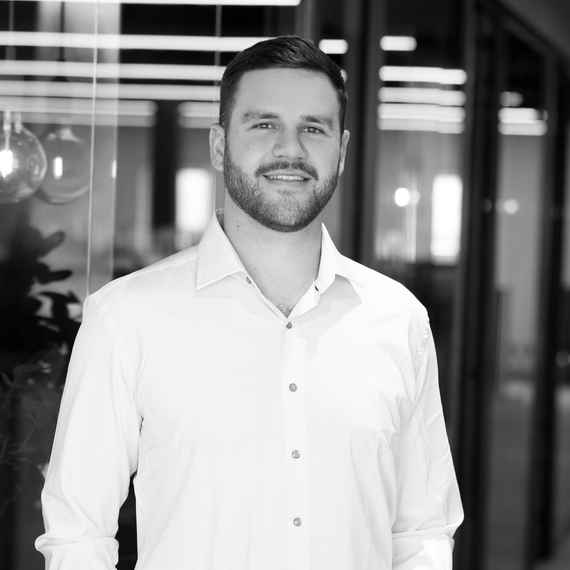 A man and a woman are sitting on a dock overlooking a lake.