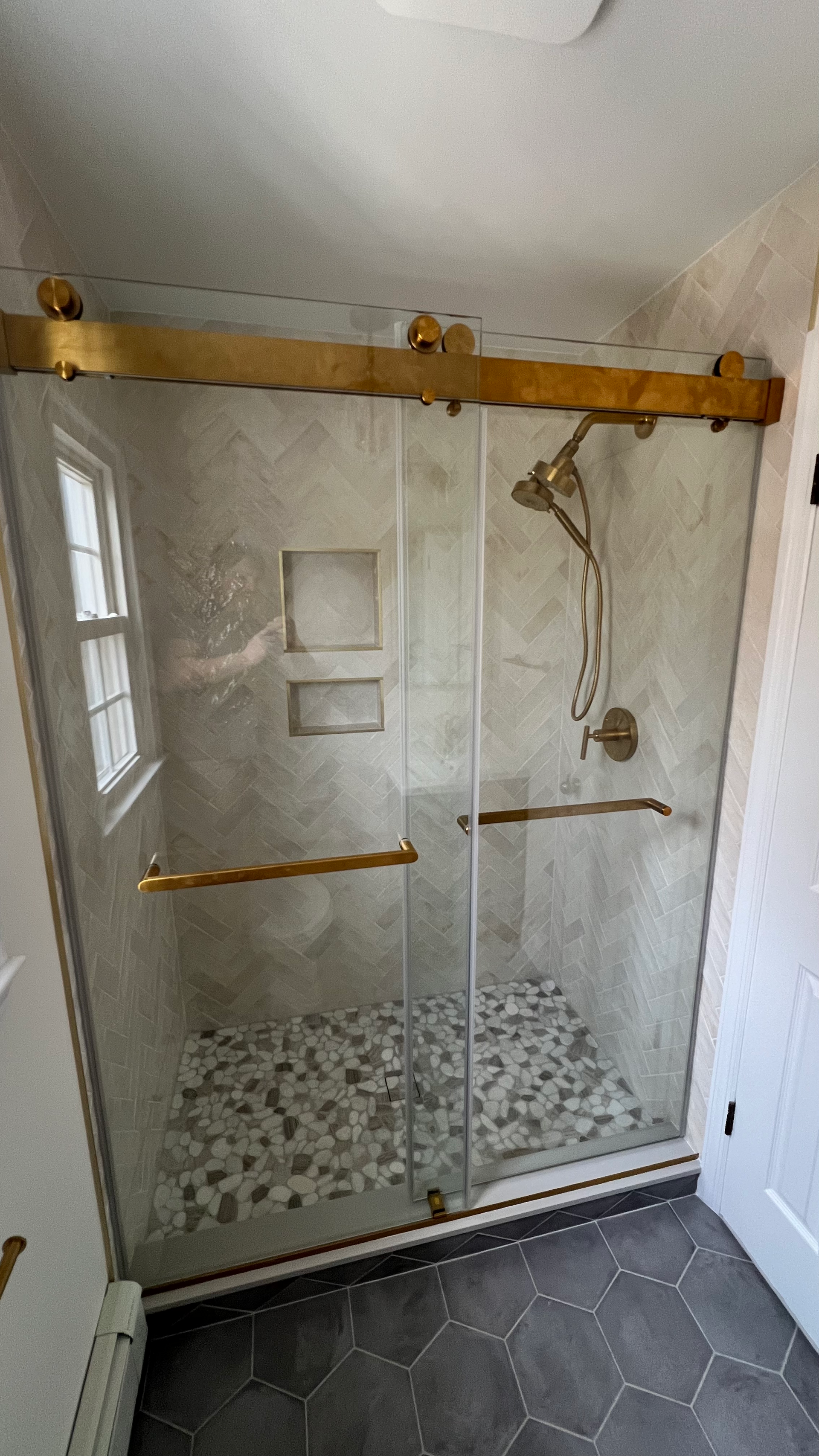A bathroom with a sliding glass shower door and a shower head.