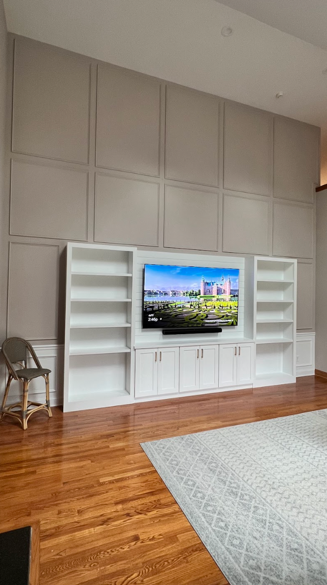 A living room with a large flat screen tv mounted to the wall.