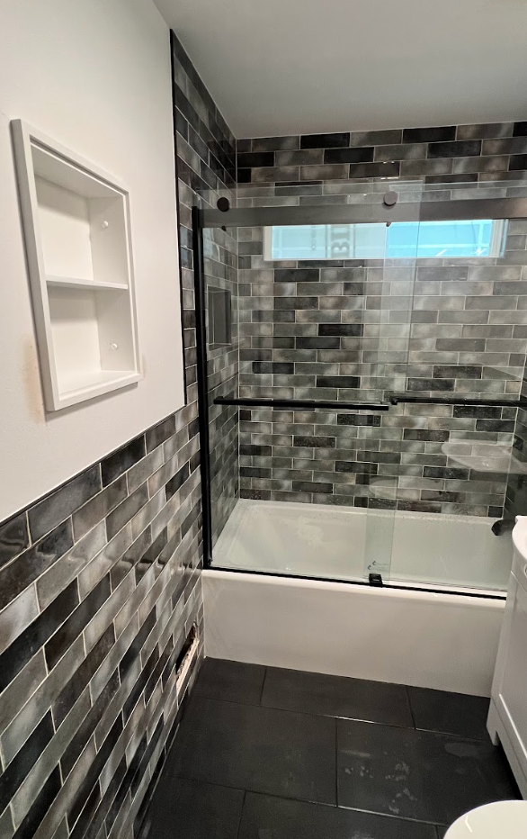 A bathroom with a bathtub , toilet , and shower.