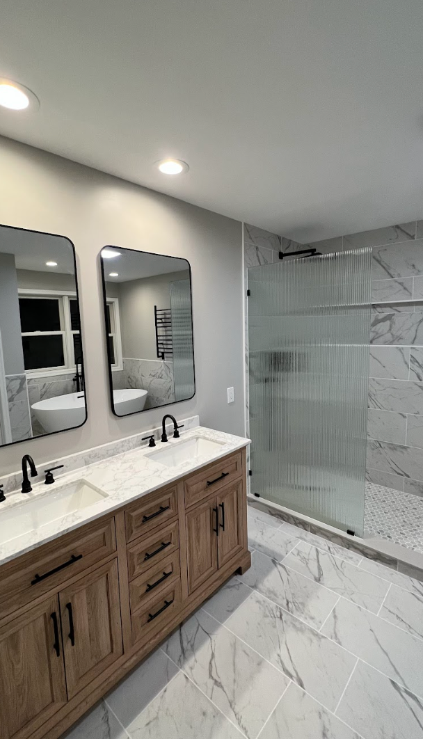 A bathroom with two sinks and a walk in shower.