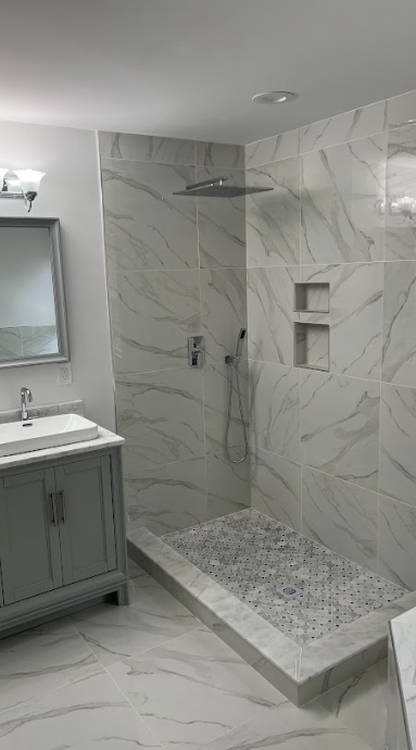 A bathroom with a walk in shower , sink and mirror.