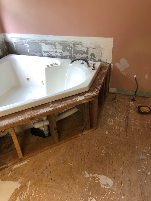 A bathtub is under construction in a bathroom