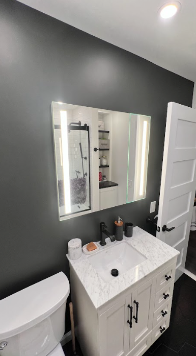 A bathroom with a sink , toilet and mirror.