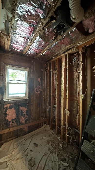 A room with a window and a ladder in it.