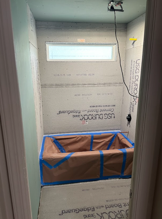 A bathroom with a bathtub and a window in it