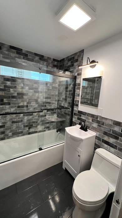 A bathroom with a toilet , sink , and bathtub.