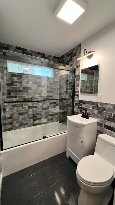 A bathroom with a toilet , sink , and bathtub.