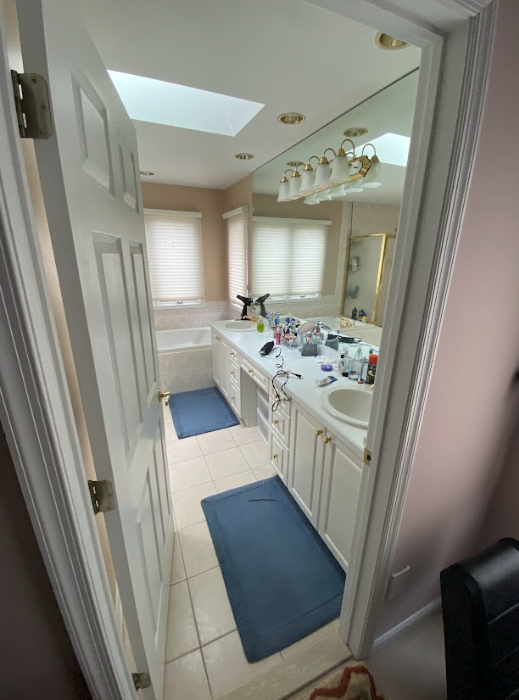 A bathroom with two sinks and a skylight in the ceiling.