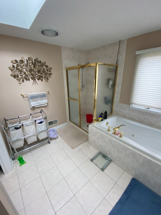 A bathroom with a bathtub , shower , and scale.