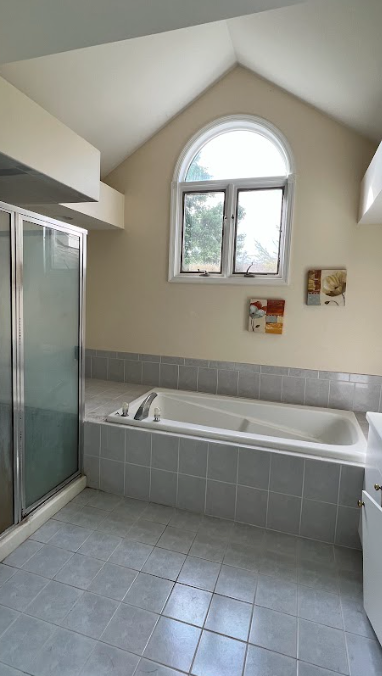 A bathroom with a bathtub and a window