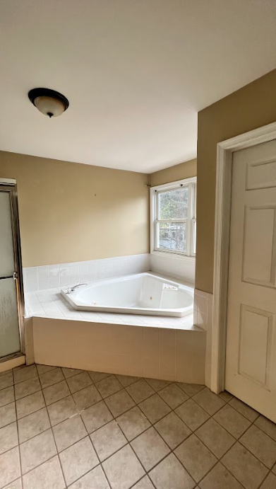 There is a jacuzzi tub in the middle of the bathroom.