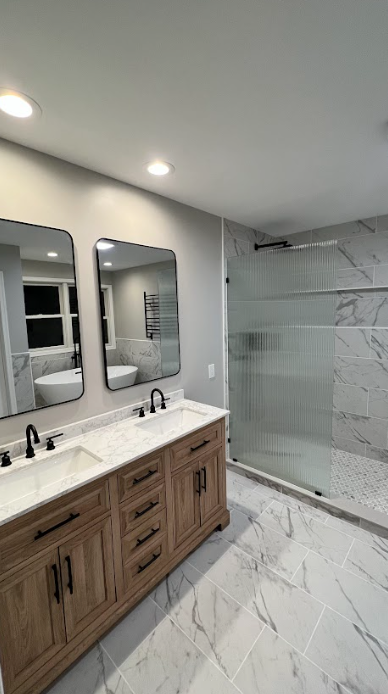 A bathroom with two sinks and a walk in shower.