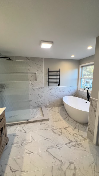 A bathroom with a tub , shower and window.