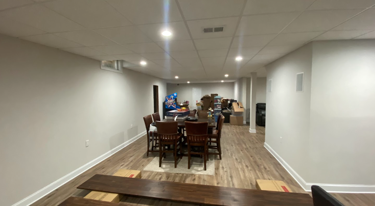 A basement with a dining table and chairs in it.