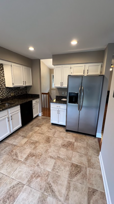 A kitchen with stainless steel appliances and white cabinets.