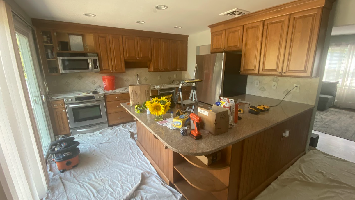 A kitchen with wooden cabinets and granite counter tops is being remodeled.