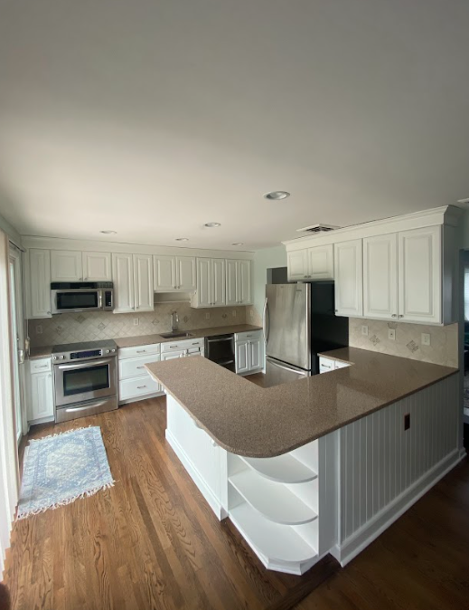 A kitchen with white cabinets and stainless steel appliances