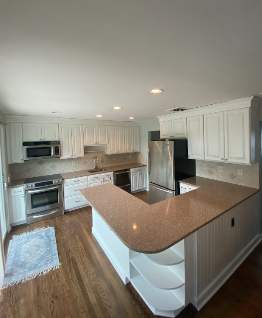 A kitchen with white cabinets and granite counter tops