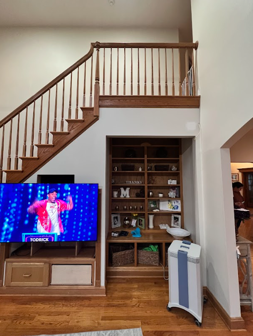 A living room with stairs and a flat screen tv