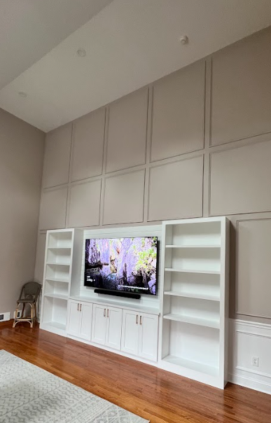 A living room with a large flat screen tv on the wall.