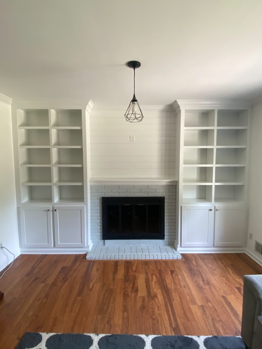 A living room with a fireplace and lots of shelves