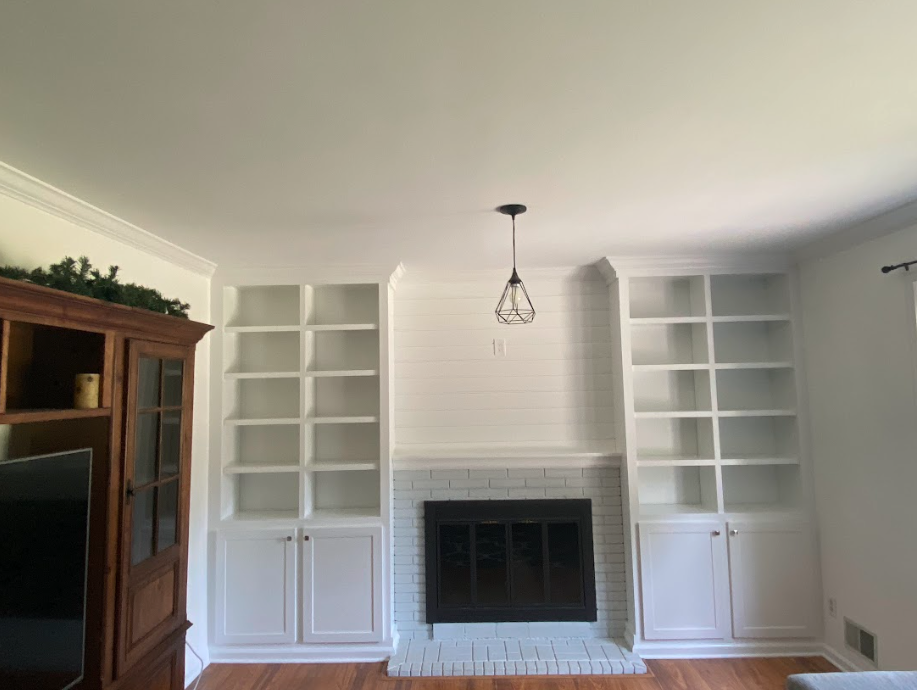 A living room with a fireplace and lots of shelves