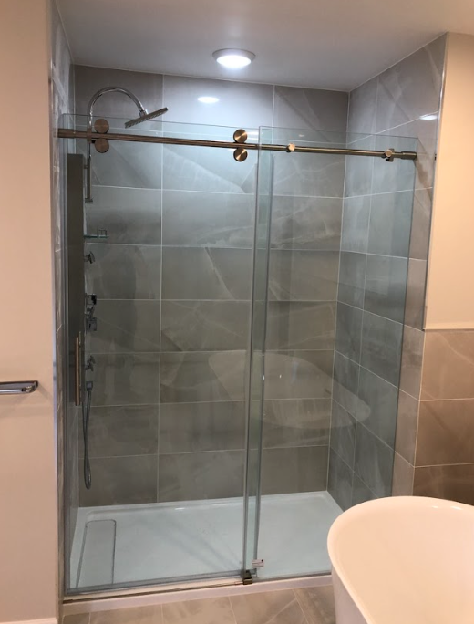A bathroom with a sliding glass shower door and a bathtub.
