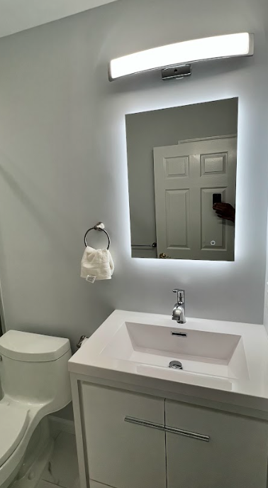 A bathroom with a sink , toilet and mirror.