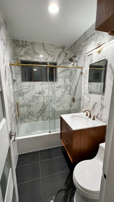 A bathroom with a toilet , sink , tub and shower.