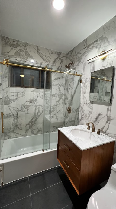 A bathroom with a sink , tub , shower and mirror.
