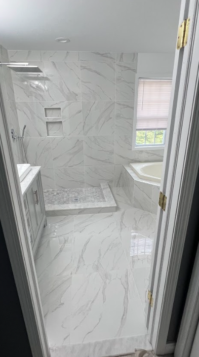 A bathroom with a walk in shower and a tub.