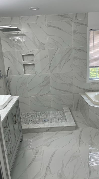 A bathroom with marble tiles and a walk in shower.