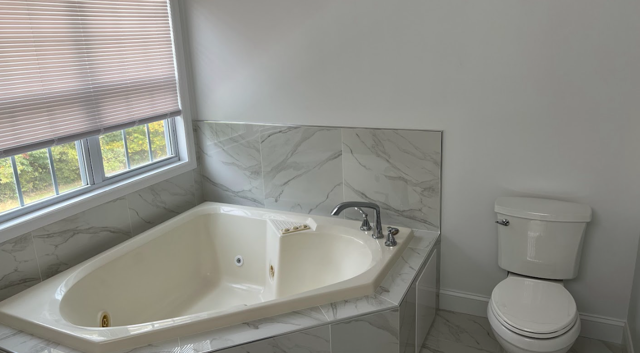 A bathroom with a jacuzzi tub and a toilet.