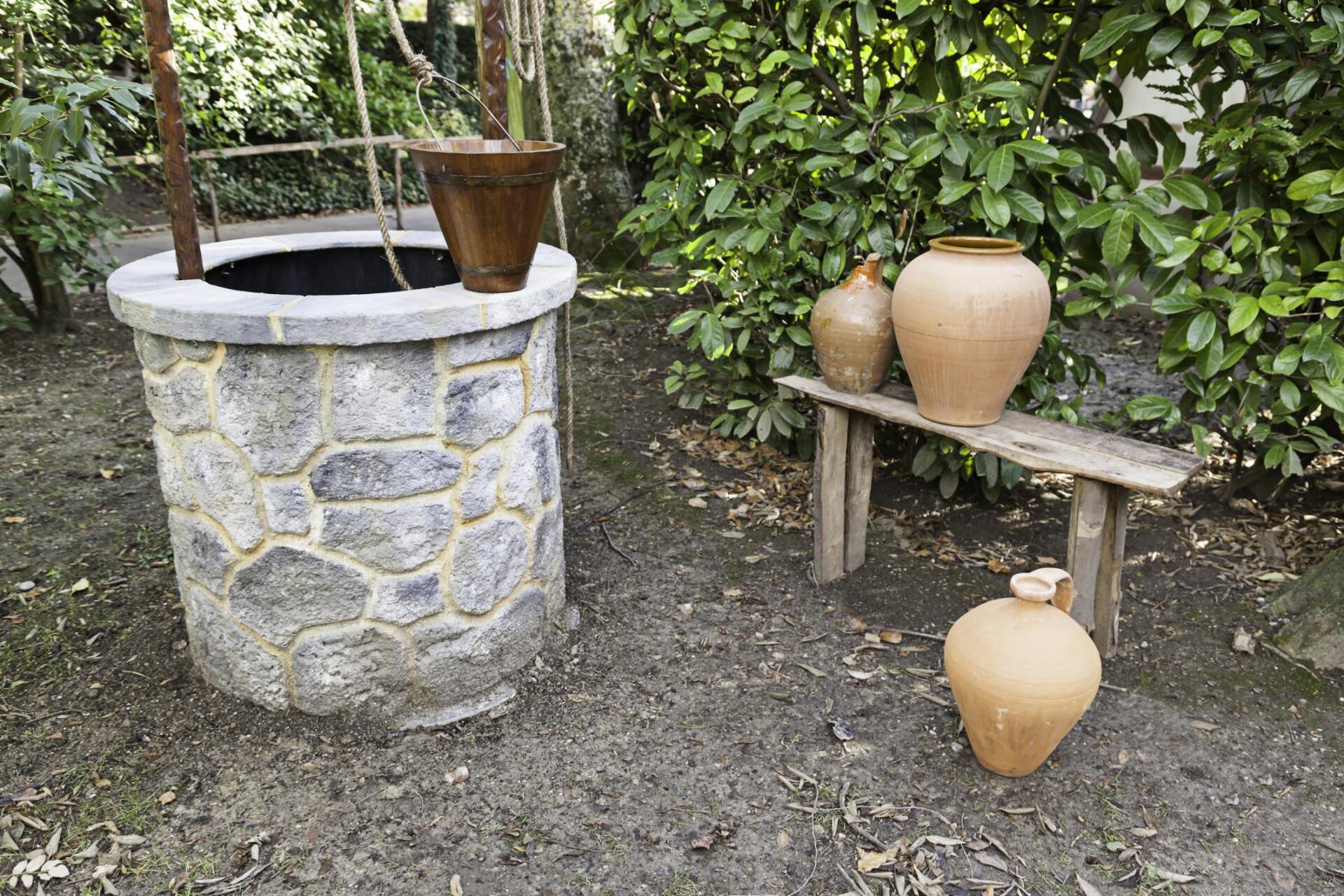 a water well with some vases on the side