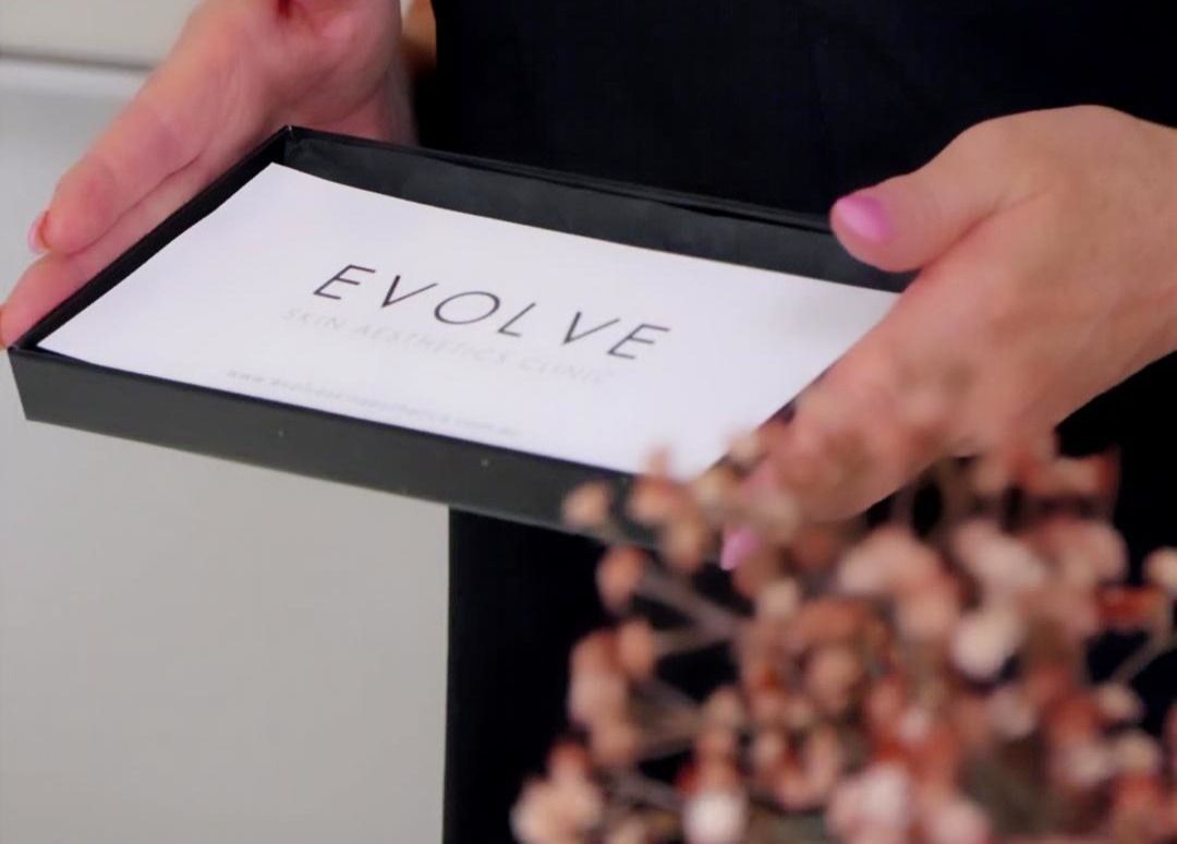 Woman feeling face with hand with hair towel covering hair