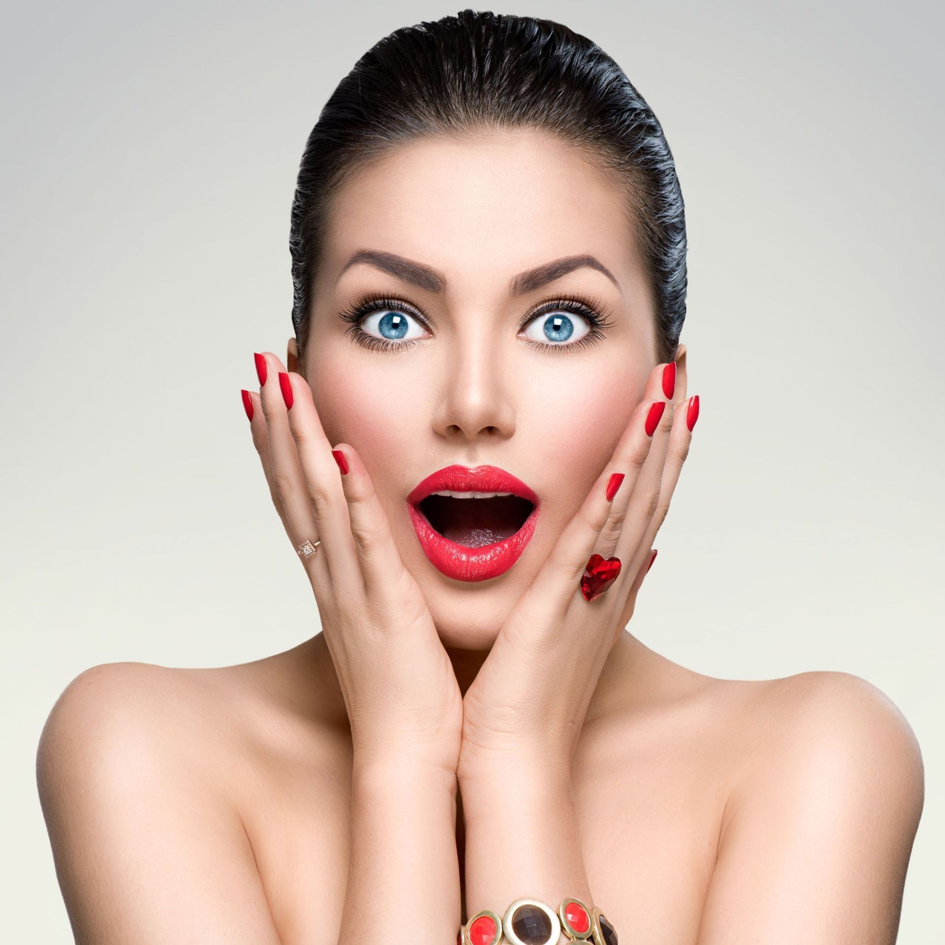 Woman wearing red lipstick holding hands up to face