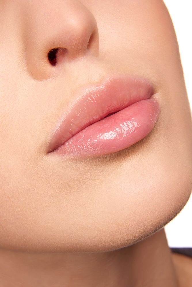 Close up of womans lips with pink lipgloss