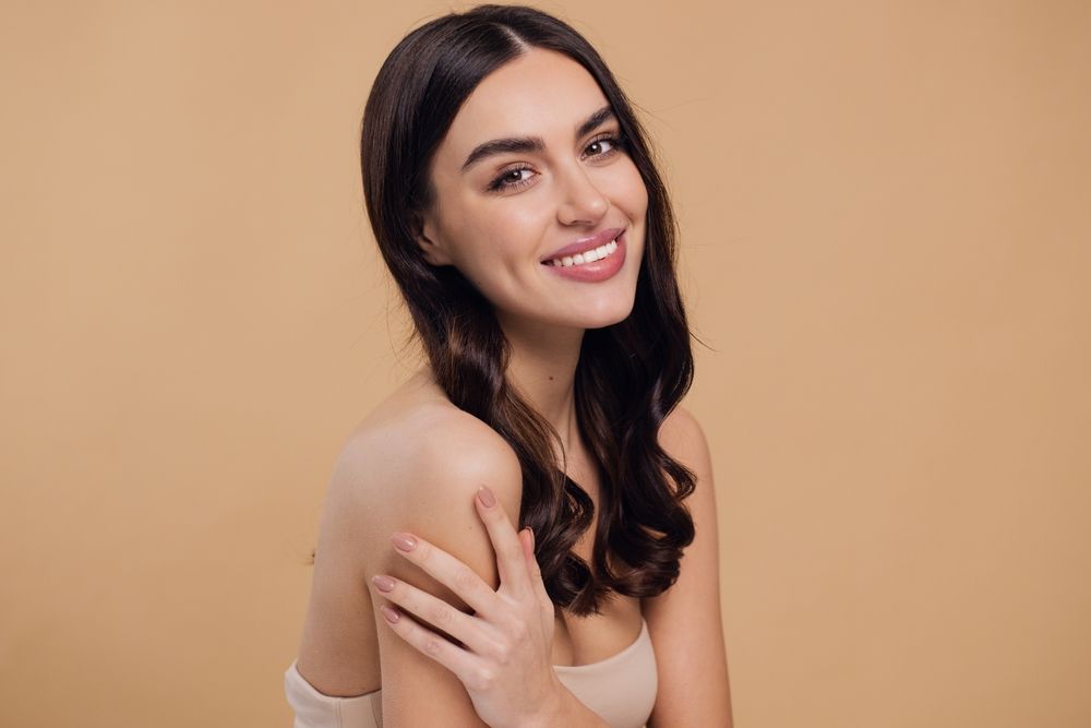 Woman holding hand on shoulder smiling