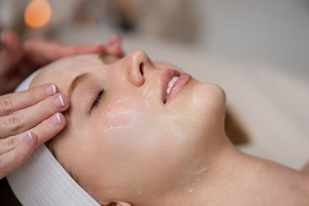 Woman with facial cream on face receiving treatment