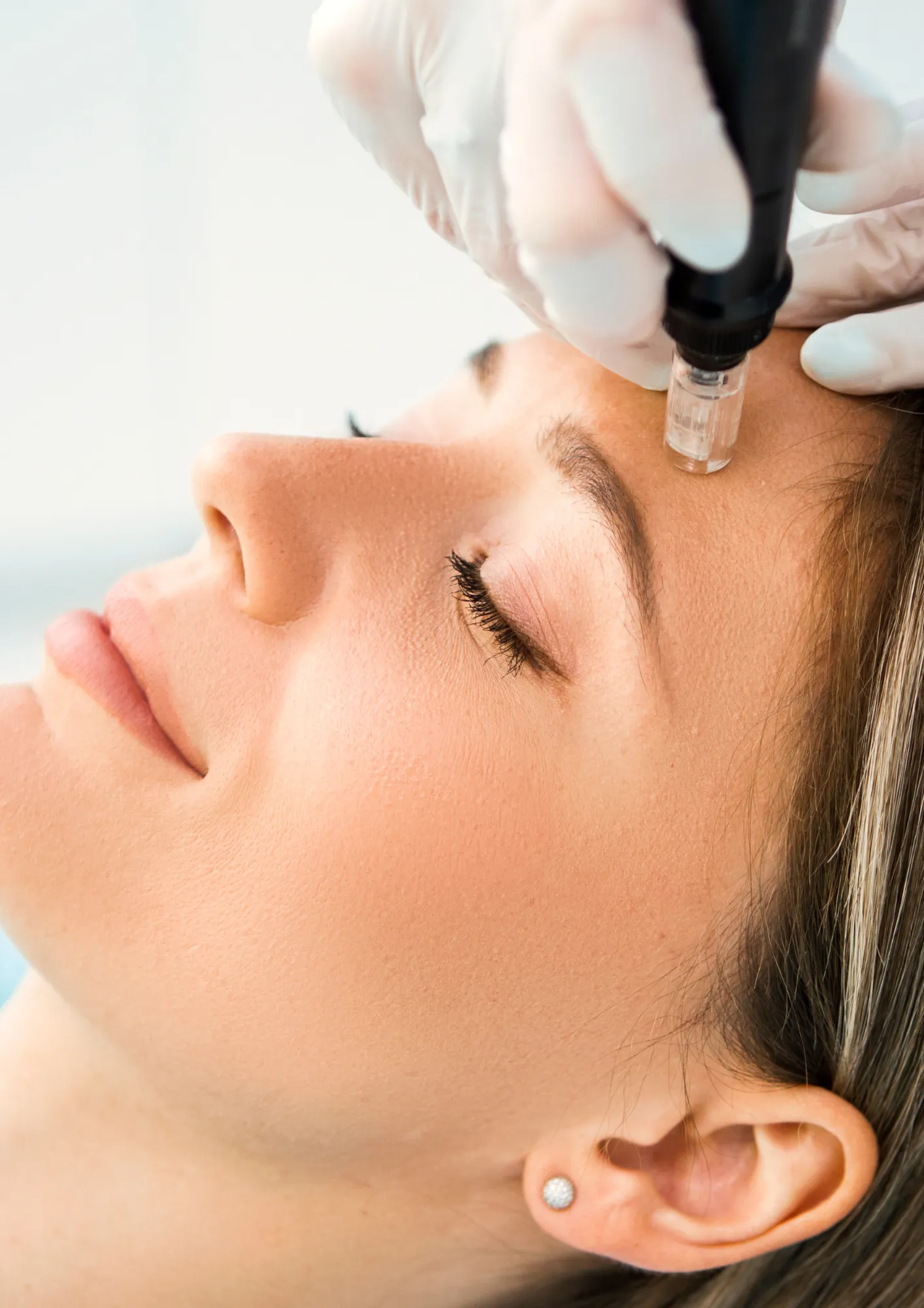 Woman receiving cosmetic treatment on face