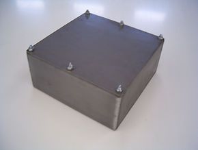 A stainless steel box is sitting on top of a white table.