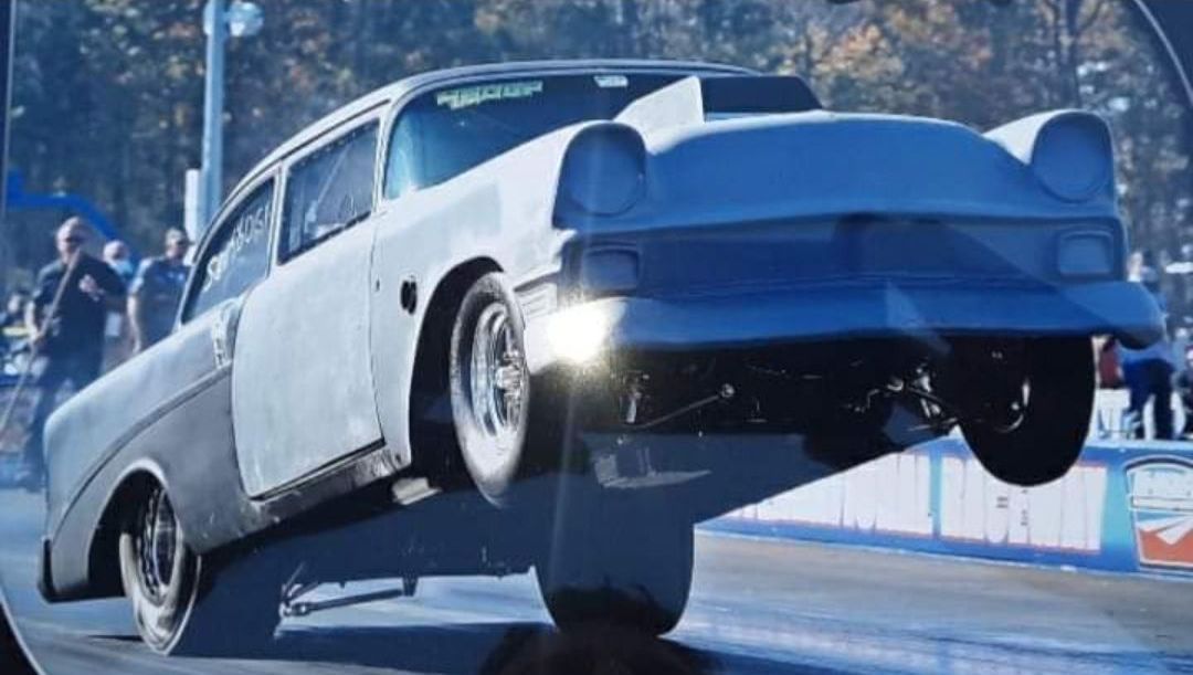 A white car is doing a trick on a race track.